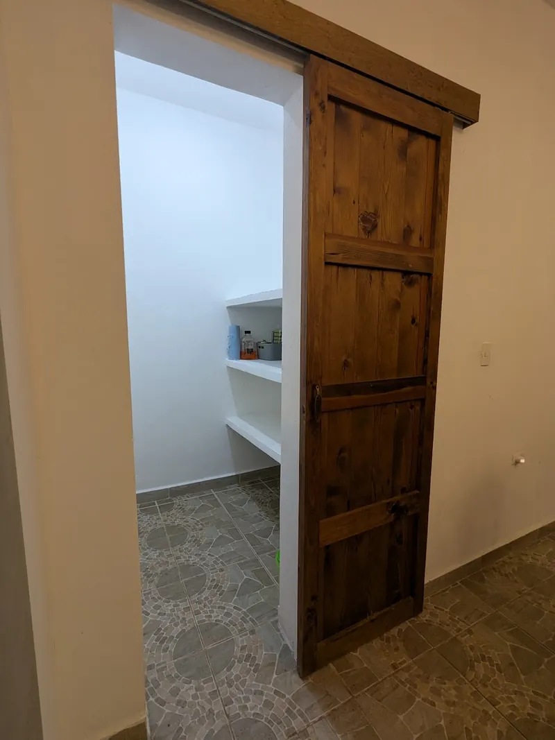 La puerta corrediza de granero hacia el segundo cuarto de guardado.