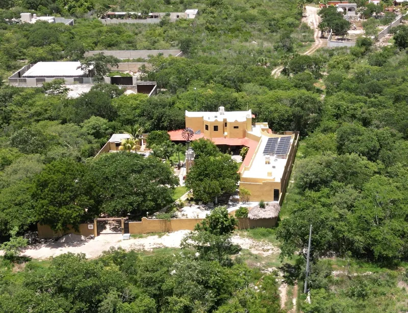 Vista aérea de la quinta entre los árboles, con los caminos y las casas vecinas.