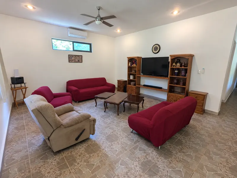 La sala, con ventilador de techo, minisplit y una ventana alta.