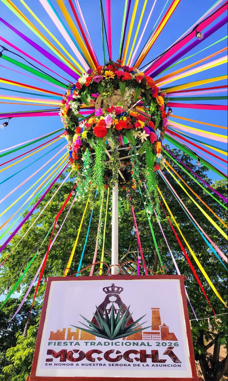 La corona de listones y flores de la fiesta, sobre el letrero «Fiesta Tradicional 2026 · Mocochá».