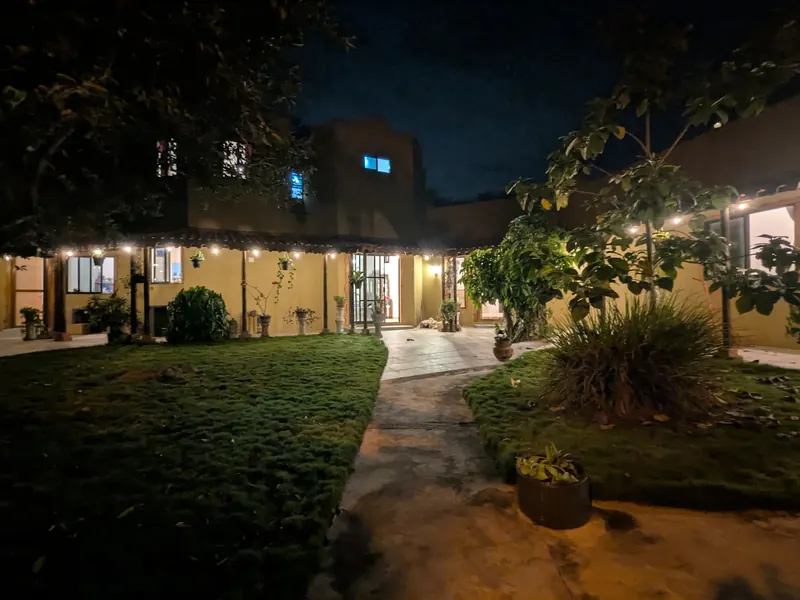 La casa y el corredor iluminados de noche.