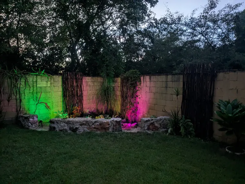 El jardín zen de noche, con luces de color.